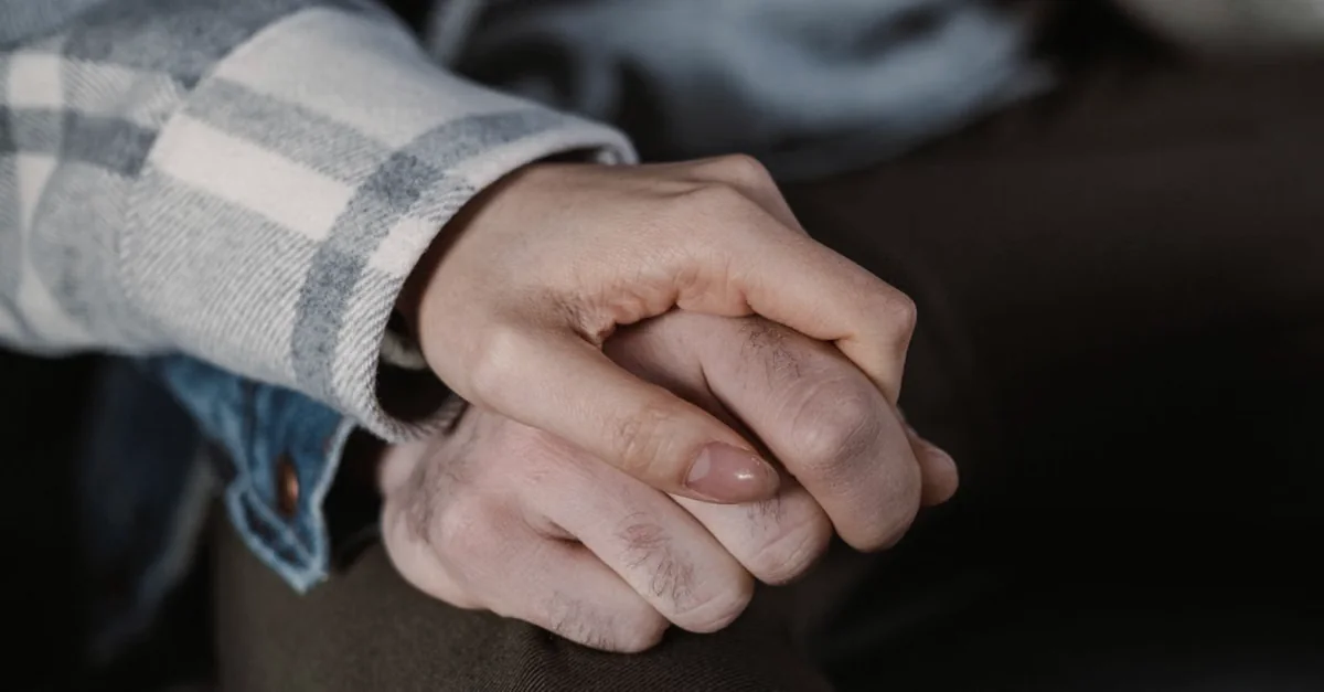 Two people holding hands closely and gently